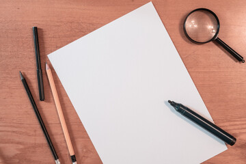 felt-tip pen and opening notebook black turned wooden pencils and magnifier on a light brown desktop. template for business © Marina Gordejeva