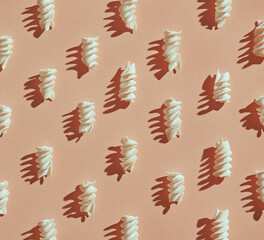 Pattern of dry beautiful Italian pasta girandole with beautiful falling shadows on a beige background.