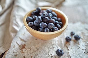 Fototapeta na wymiar Image of blueberries in wooden bowl on rustic village table.