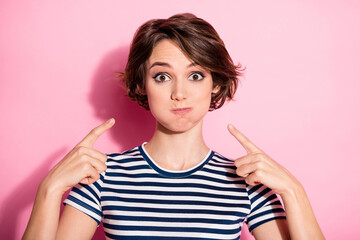 Portrait of careless crazy funky girl inflate her cheeks point index finger show joke wear good...