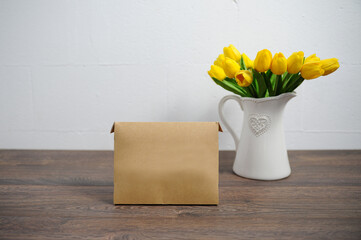 Yellow tulips and boxes on a wooden table.