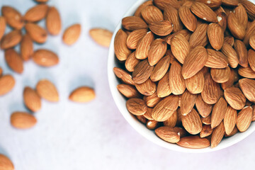 Almonds on a white wooden floor are perfect for a bright and beautiful breakfast.