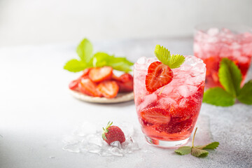 Refreshing summer drink with strawberry slices in glasses on white background
