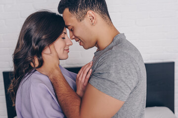 side view of bi-racial man hugging cheerful girl with closed eyes