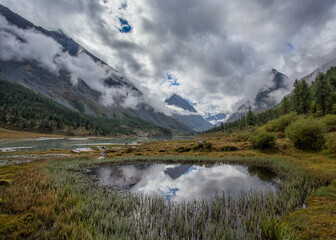 Akkem Lake at the foot of Belukha Mountain in Altai. Cloudy. Reflection in water.