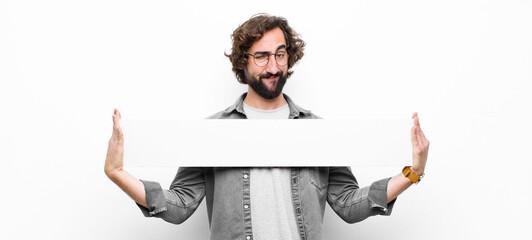 young crazy cool man holding an empty placard or banner against white wall