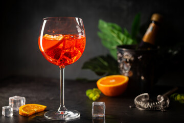 Aperol spritz cocktail in glass with fresh orange on dark background