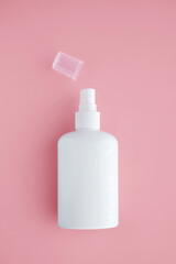 White cosmetic bottle on pink background.