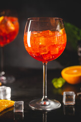 Aperol spritz cocktail in glass with fresh orange on dark background