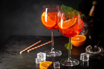 Aperol spritz cocktail in glass with fresh orange on dark background