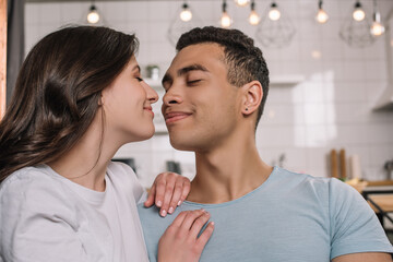 Fototapeta premium happy interracial couple with closed eyes smiling at home