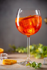 Aperol spritz cocktail in glass with fresh orange on gray background
