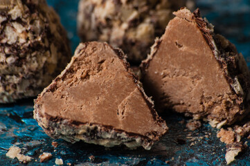 Delicious chocolate candies in waffle crumbs cut in half closeup macro, side view