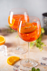 Aperol spritz cocktail in glass with fresh orange on light background