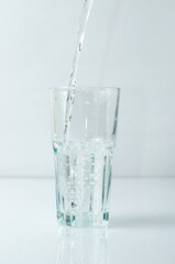 Splashing liquid, water is pouring into a glass