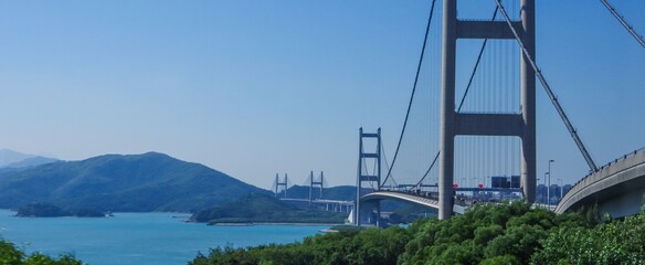 Modern concrete suspension bridge with gleaming reflection of waves in sunlight