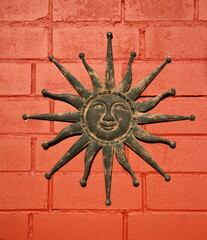 Metal sun on a brick wall