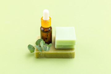 Soap, eucalyptus and serum on green backgriund. Skin care. Minimalism