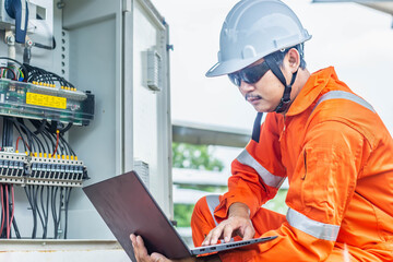 Engineers upload data of power energy to a laptop for checking the performance of the solar panel...