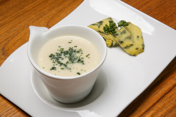 Creamy vegetable soup served in a bowl on the restaurant table