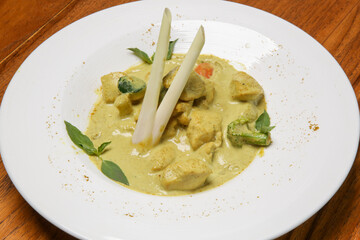 Stew chicken curry in coconut sauce served in a plate, close up horizontal view from above
