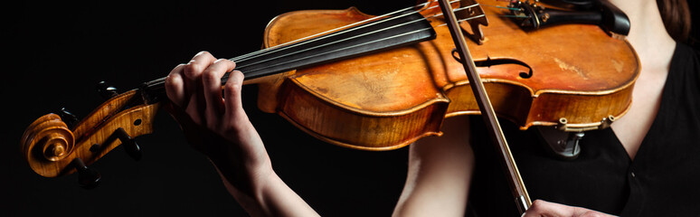 Obraz premium partial view of female musician playing on violin isolated on black, horizontal image