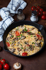 Chicken fillet in creamy sauce with mushrooms and tomatoes