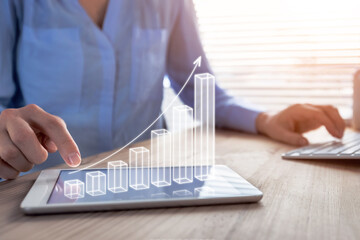 Business success and profit displayed by 3d growing bar chart, successful businesswoman working in...