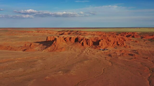 Aerial view of the Bayanzag flaming cliffs at sunset in Mongolia, found in the Gobi Desert, 4k