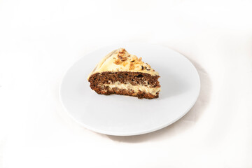 A slice of carrot cake being cut. On the white plate, isolated in white.