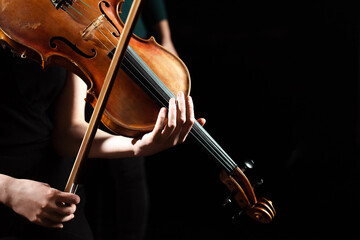 partial view of female musician performing symphony on violin isolated on black