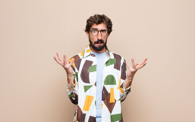 young cool bearded man expressing a concept against flat wall