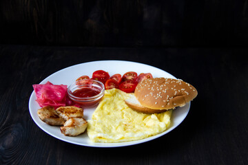 Omelet with three pieces of chicken, cherry tomatoes, red cabbage, bread and red sauce on the white plate. Healthy and tasty meal for the diet. Delicious breakfast or lunch without GMO