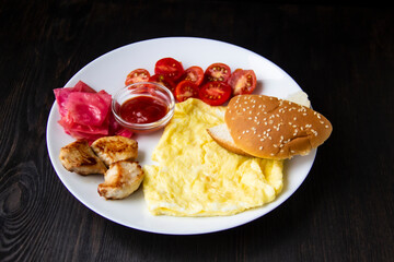 Omelet with three pieces of chicken, cherry tomatoes, red cabbage, bread and red sauce on the white plate. Healthy and tasty meal for the diet. Delicious breakfast or lunch without GMO