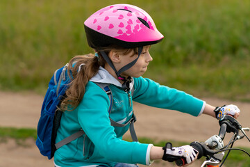Fototapeta na wymiar Portrait of a little girl on a bicycle and in a helmet.