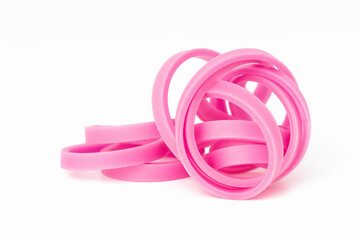 Pink elastic bands entwined shot against a white background