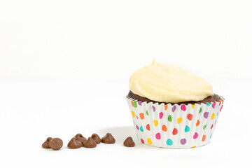 Chocolate cupcake/muffin in spotty cake case shot against white background
