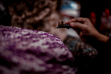 Solo Indonesia, June 03 2020 : Traditional canting for making Batik Tulis in Surakarta with background colorful Fabric