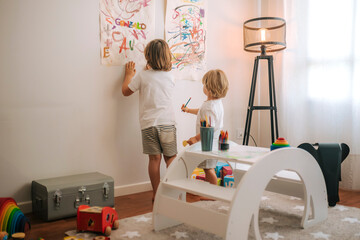 Little blond children plays painting at home. entertainment during quarantine. family at home