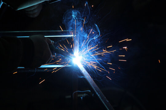 Sparks from welding. A man will weld metal. Workplace of the welder. Garage welder