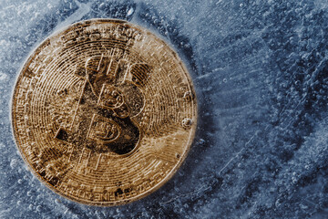 Golden symbol bitcoin frozen and covered with ice. Concept of Cryptocurrency crisis and the fall of the cost of bitcoin