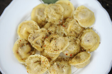 Dumplings on a wooden table with herbs tomatoes
