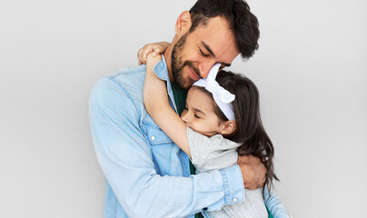 Happy father hold embrace his cute daughter. Loving daddy and his little girl cuddling and enjoying time together. Childhood and fatherhood concept. - obrazy, fototapety, plakaty