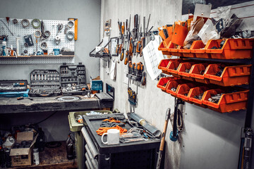 Maintenance station, motorcycle and car repair, mechanical equipment on the wall, a set of tools in...