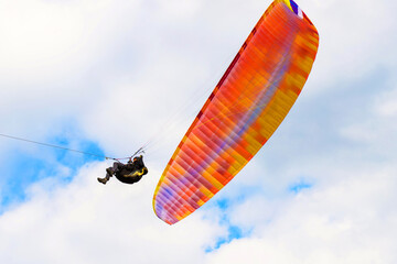 paraglider in a blue cloudy sky