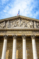 Fototapeta na wymiar Low angle view of the pediment of the Palais Bourbon, seat of the french National Assembly in Paris, France, bearing the inscription Assemblée Nationale in golden letters.