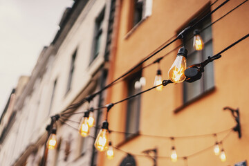 Street lamps in the background of European buildings in the evening, lighting and decoration of public spaces. Abstract holiday background