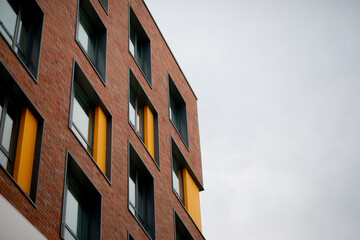 the corner of a building under construction on a brick roof with windows