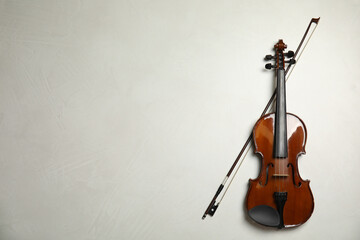 Beautiful violin and bow on grey stone table, flat lay. Space for text