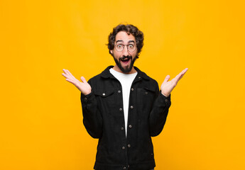 young crazy handsome man feeling happy, excited, surprised or shocked, smiling and astonished at...